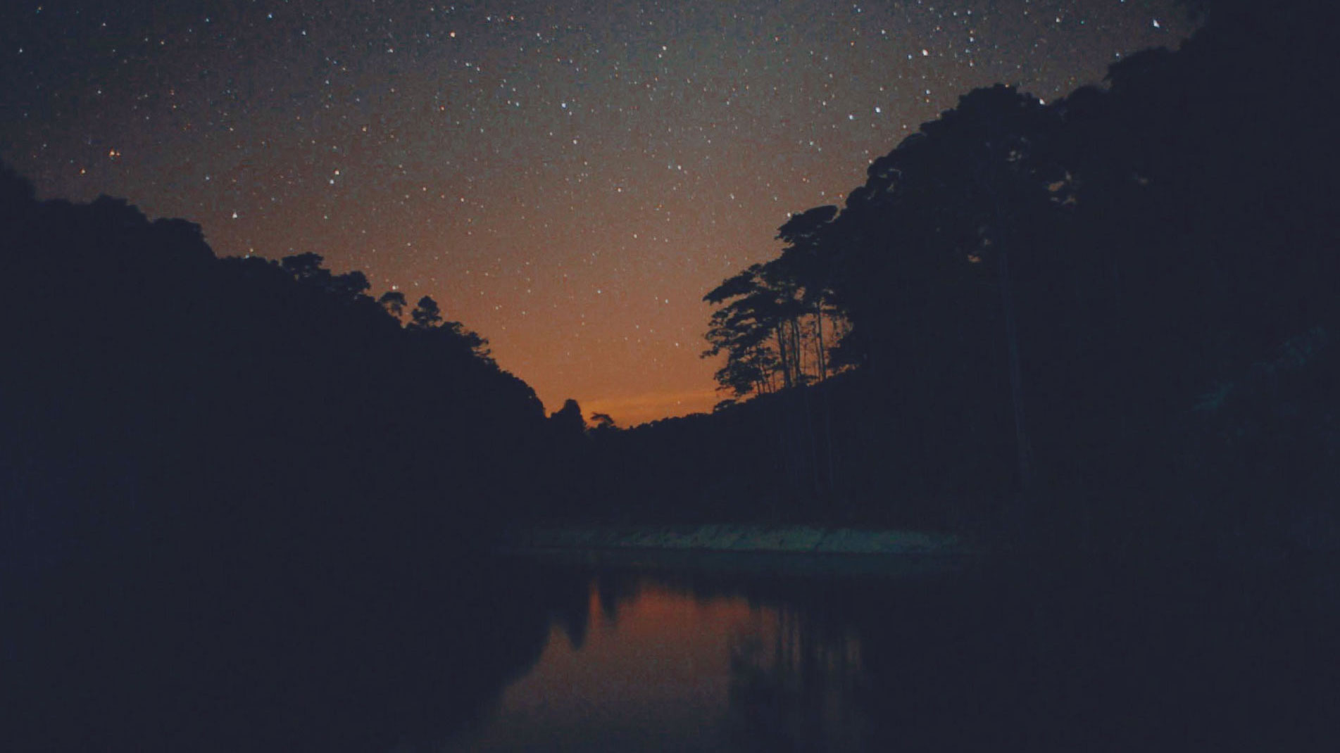 The starry night sky casts its shadow on a sandy riverbank in Perak.